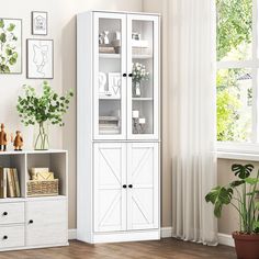 a white bookcase with glass doors in a living room next to a potted plant