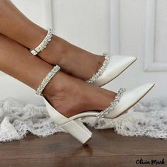 a woman's legs wearing white high heels and diamond bracelets on her ankles