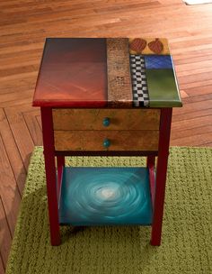 a small table with a drawer on top of it and a rug underneath the table