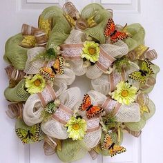 a wreath with flowers and butterflies on the front door