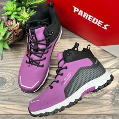 a pair of purple hiking boots next to a box