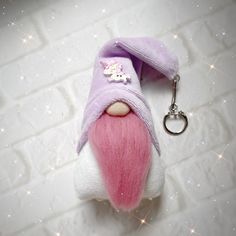 a small stuffed animal with a keychain attached to it's side on a white brick wall