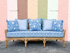 a couch sitting in front of a colorful wall with pillows on it's back