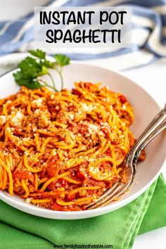 a white bowl filled with spaghetti and topped with parmesan cheese, tomato sauce