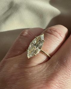 a woman's hand with a yellow diamond ring on it