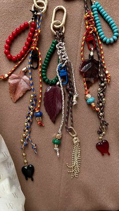 several different types of bracelets are laying on a bed together, including beads and charms