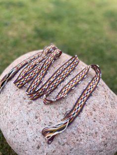 several bracelets sitting on top of a rock