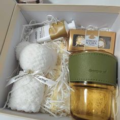 an open box with some items in it including a teddy bear, soap and lotion