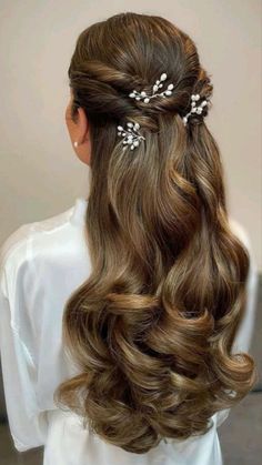 the back of a woman's head with long hair and flowers in her hair