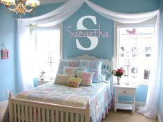 a bedroom decorated in blue and white with a monogrammed wall hanging above the bed