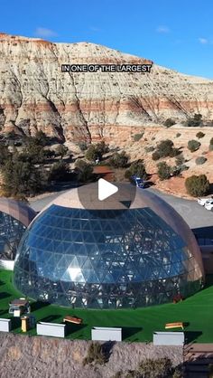 an aerial view of the inside of a large glass building with mountains in the background