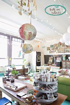 a room filled with lots of clutter and hanging lights above the table in front of it