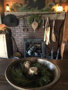 a large metal bowl filled with plants next to a fireplace