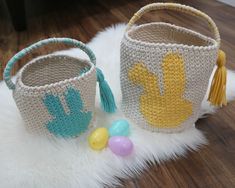 two crocheted baskets sitting on top of a white rug next to an easter egg