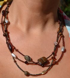 "This fun and beautiful little number is composed of browns and tans.  A gorgeous combination of varied seed beads, precious stones, shell, ceramic, cats eye, jasper beads and swarovski crystals.  It is a unique piece that is fun and versatile and sure to delight! Sterling silver trigger clasp and findings. Necklace measures approximately just over 20\" at shortest strand. Browse more from my shop here: https://www.etsy.com/shop/uniquebeadingbyme?ref=seller-platform-mcnav" Artisan Brown Beaded Necklace For Beach, Multi-strand Brown Beads For Gifts, Brown Multi-strand Beads For Gift, Brown Polished Beads For Beach, Bohemian Brown Czech Glass Jewelry, Handmade Brown Czech Glass Beads, Bohemian Brown Jewelry With Spacer Beads, Bohemian Brown Czech Glass Beaded Necklaces, Bohemian Brown Beaded Necklace With Czech Glass