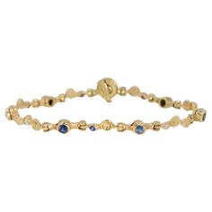 Immerse yourself in the epitome of elegance with this stunning 18K Yellow Gold Bracelet by Audrius Krulis. Adorned with nine vibrant blue sapphires and five scintillating round brilliant cut diamonds, this bracelet is a masterpiece of luxury and sophistication. The deep, royal blue of the sapphires is expertly contrasted by the brilliant sparkle of the diamonds, each gemstone meticulously set to maximize its natural beauty. The 18K yellow gold setting adds a warm, timeless touch, making this bracelet a versatile accessory that can elevate any ensemble. Whether worn alone or stacked with other pieces, this bracelet is sure to draw admiration and become a cherished addition to your jewelry collection. Audrius Krulis is a distinguished jewelry designer renowned for his innovative designs and Luxury Yellow Gold Multi-stone Bracelet, Luxury Gold Diamond Bracelet With Multi-stone, Gold Multi-stone Diamond Bracelet, Luxury Yellow Gold Multi-stone Bracelets, Classic Gold Multi-stone Bracelets, Classic Yellow Gold Multi-stone Bracelets, Elegant Multi-stone Yellow Gold Diamond Bracelet, Elegant Multi-stone Diamond Bracelet, Classic Yellow Gold Bracelets With Multi-stone