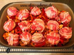 a pan filled with meat and vegetables on top of a counter next to a wire rack