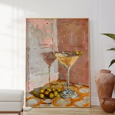 a painting on the wall next to a vase with some olives and a martini in it