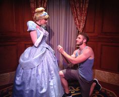 a man kneeling down next to a woman in a dress