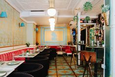 the interior of a restaurant with tables, chairs and booths lined up against the wall