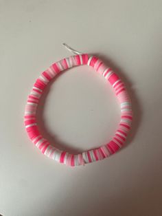 a pink and white bracelet on a table