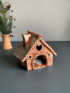 a ceramic bird house next to a potted plant