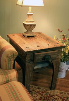 a table with a lamp on it next to a chair