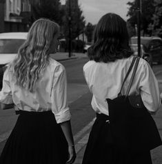 two women walking down the street with their backs to each other