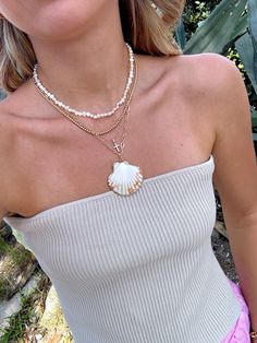 Our Shell Yeah Gold Filled Necklace is the perfect necklace for the beach lover. This necklace features 24k Gold Filled chain, real sea shell with gold plated edges, and lightweight for layering. Style this necklace with your favorite summer dress, your next beach trip with your fave bikini, or with your fave graphic tee! Please be gentle with your shell ♡ All accessories are final sale. Dainty Shell Necklace For Beach, Summer Ocean-inspired Necklaces, Beach Season Strand Necklaces, Beach Shell-shaped Necklace With Clavicle Chain, Summer Shell Necklace For Vacation, Beachy Shell Necklaces For Summer, Shell Beachy Jewelry For Summer, Beachy Shell Necklace For Summer Vacation, Shell-shaped Clavicle Chain Necklace For Beach