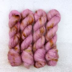 two skeins of pink yarn sitting next to each other on a white surface