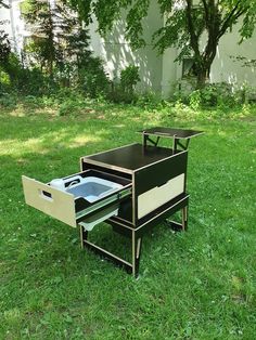 an open drawer in the grass near a building