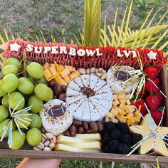 a platter filled with cheese, fruit and crackers