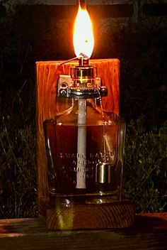 a lit candle sitting on top of a wooden block