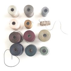 several spools of thread are shown on a white surface