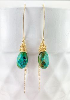 "These one of a kind drop earrings are lightweight and dazzling. Perfect for a night on the town combining comfort and glam. Measuring in at nearly 3\" from top to bottom they are the perfect addition to any outfit. Boho wire wrapping and chain in 14 k gold fill compliment the intense turquoise greens and blues. PLEASE NOTE: While these earrings are custom made from the same gorgeous strand of turquoise they will look a little different. They are carefully wire wrapped especially for you! They a Turquoise Wire Wrapped Teardrop Dangle Earrings, Turquoise Bohemian 14k Gold-filled Earrings, Turquoise 14k Gold Filled Bohemian Earrings, Bohemian Turquoise 14k Gold-filled Earrings, Bohemian Turquoise 14k Gold Filled Earrings, Turquoise Gold Bohemian Earrings, Turquoise 14k Gold-filled Earrings With Ear Wire, Turquoise 14k Gold Filled Drop Earrings, One Of A Kind Gold Teardrop Earrings