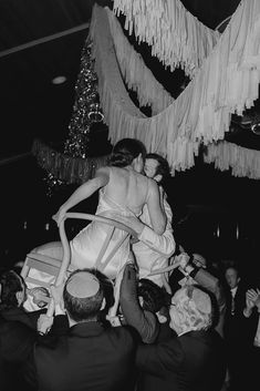 black and white photograph of woman being lifted by man