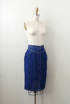 "~ 1970s denim skirt featuring, a high yoked waist lots of white top stitching belt loops on the waistband a pocket at each hip it snaps all the way down the front falls to just below the knee ~ of a mid weight, cotton denim in a dark blue ~ labeled \"Cheryl Tiegs\", (supermodel turned fashionista), this is tagged a size 8, measurements when laid out flat are: 12 1/4 inches at the waist 18 inches at the hip 25 inches from waist to hem ~ would best fit a size small to medium ~ in good, preworn, v High Waisted Denim Skirt Pencil, Jeans Inspiration, Cheryl Tiegs, Sewing Jeans, Denim Pencil Skirt, Skirt Vintage, Style Skirt, Jeans Rock, High Waisted Denim