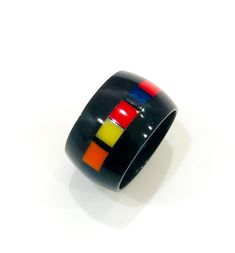 Black band ring with a band of small colored pieces of Corian® assembled with a special and unique technique. The end result is truly original. Despite being minimal it has a strong personality. The material used is strong and completely hypoallergenic. This exclusive processing of high craftsmanship and design does not allow color duplications, therefore each piece is unique and numbered. The measurements of the published ring are: Italian size 20- size US 9-1/2-height 13 mm, weight 3 grams (very light!) If you like the model and the color but it is not of your size, contact me and send me your size. I will make one for you but it will never be the same. I will send you the photo and you will buy it only if you like it Corian Jewelry, Black Band Ring, Strong Personality, Band Ring, Ring Designs, Size 20, Are You The One, Band Rings, Jewelry Rings