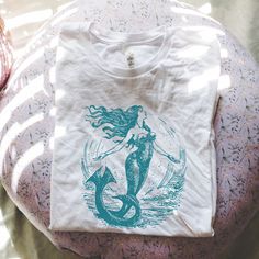 We love this fun, colorful unisex Teal Vintage Mermaid design T-shirt! This tee is soft and super comfy and is made of 100% cotton. Heather tees are a soft cotton-poly blend. We use BELLA+CANVAS for our T-shirts!  Note: these are custom items that are printed when ordered.  Items may be slightly different from the images in the listing. FABRICATION * Solid Colors: 100% Ringspun Cotton * Heather Colors: 52% cotton, 48% polyester * Runs true to size SIZING This style is a unisex t-shirt. If you ar Mermaid T Shirt, Mermaid Tshirt, Mermaid Design, Mermaid Shirt, Mermaid Outfit, Mermaid Lover, Vintage Mermaid, Blue Mermaid, Beach Shirt