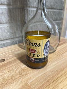 a candle that is sitting on top of a wooden table next to a glass bottle