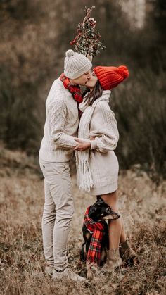 two people are standing in the grass with their noses close to each other and kissing