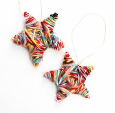 two christmas ornaments made out of candy canes are hanging from strings on a white background