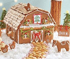 a gingerbread house decorated for christmas with cookies and other holiday treats in the snow