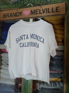 Brand new never worn white T-shirt from Brandy Melville aleena Style with Santa Monica California graphics and raw edges this never got stamped with a John Galt signature stamp. Fit size small or medium best Vintage White T-shirt With Letter Print, Vintage White T-shirt With Text Print, Vintage White Tops With Text Print, Vintage White Tops With Letter Print, Brandy Melville T Shirts, Signature Stamp, Santa Monica California, John Galt, Handmade Brand