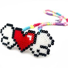 two beaded sheep with a heart on their backs, one being held by a string