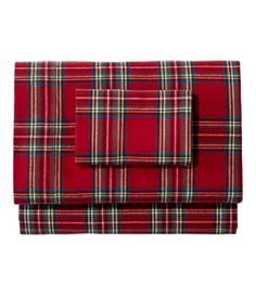 a red and green plaid blanket on top of a bed