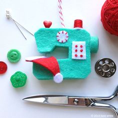 a sewing machine ornament next to scissors and yarn