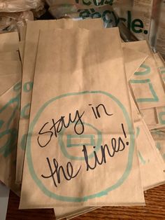 six brown paper bags with the words stay in the lines written on them, sitting on a table