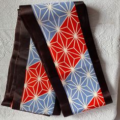 "Hanhaba obi belt for Japanese kimono. Colorful red, blue, & white colorful geometric design on front with black border. Plain black on back. Measures approx. 22.5 cm (8.75\") wide,  3.81 meters long (150\" or 381 cm) Condition: The black color is faded unevenly and sometimes appears purple. Some discoloration to black fabric on both sides & red spots on front." Obi Kimono, Velvet Obi Belt, Japanese Obi Belt, Kimono Obi Bags, Obi Japanese, Obi Belt, Belt Design, Plain Black, Japanese Kimono