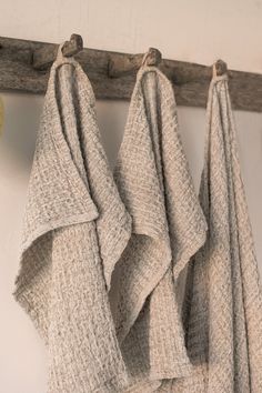 three towels hanging on a wooden rack